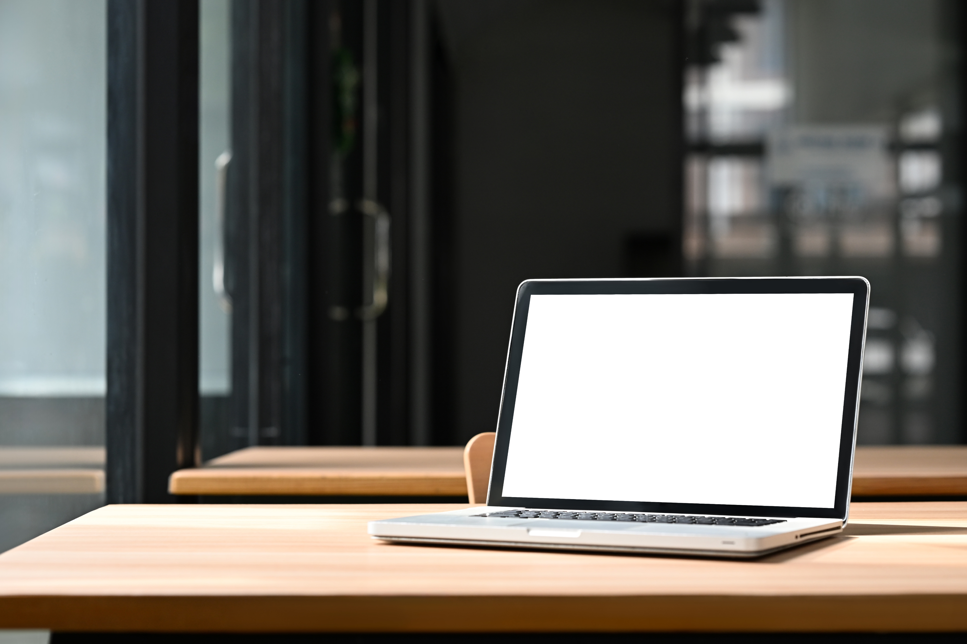 Freier Tisch auf dem ein offener Laptop steht