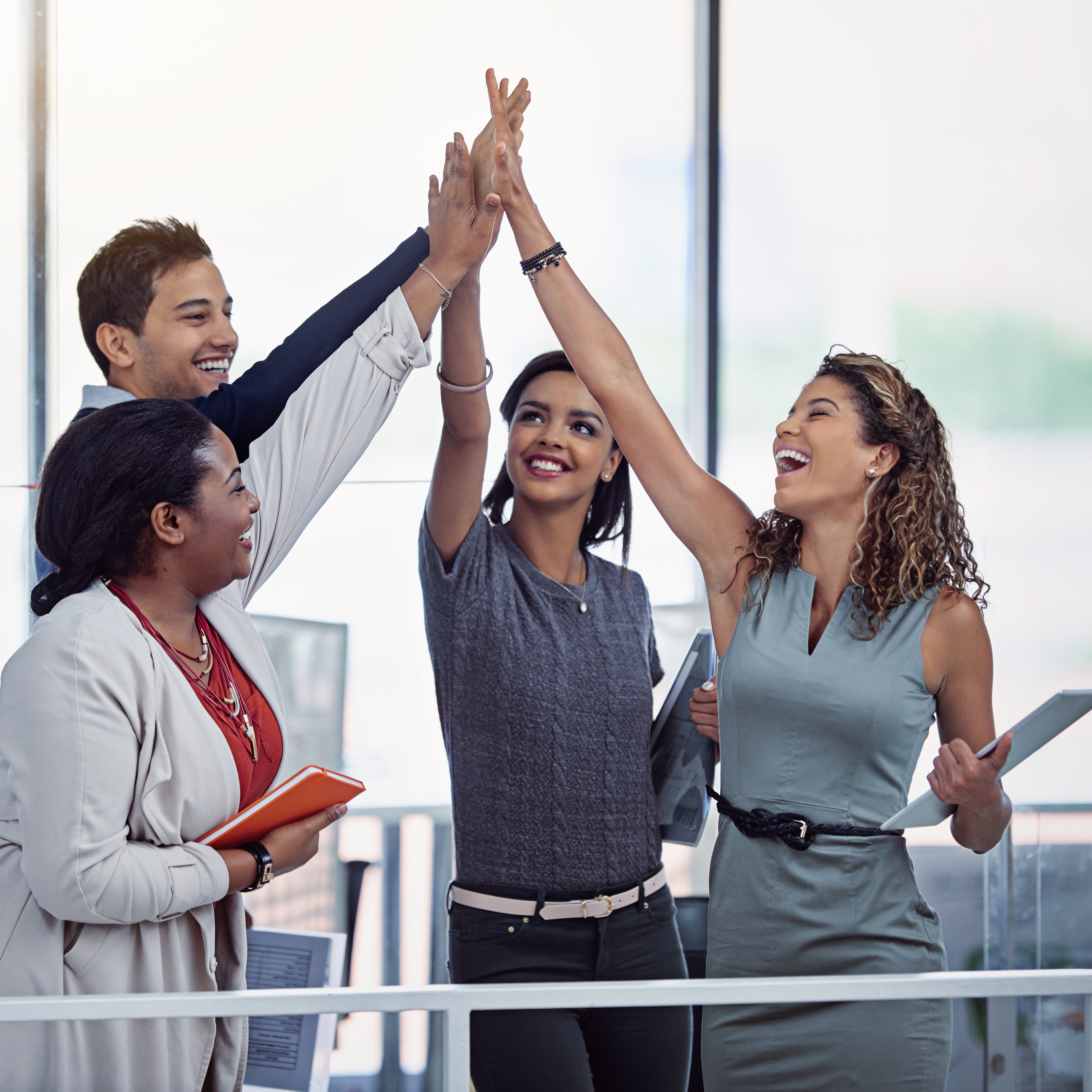 People from diverse backgrounds giving each other a high five.